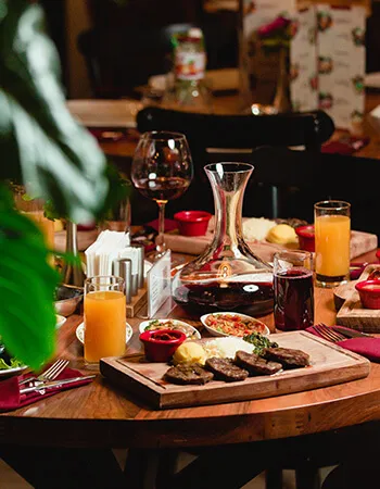 A dining table set with food, wine glasses and a carafe for a shared meal
