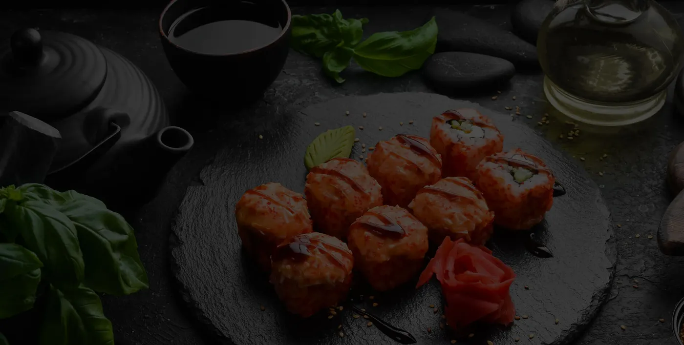 A plated starter with fresh herbs on a dark, textured table setting
